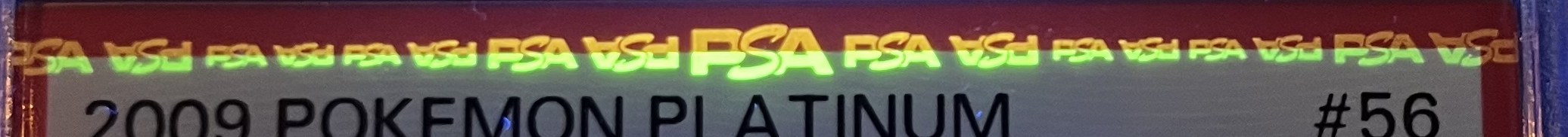 Front UV zoom — green PSA repeating band above the label